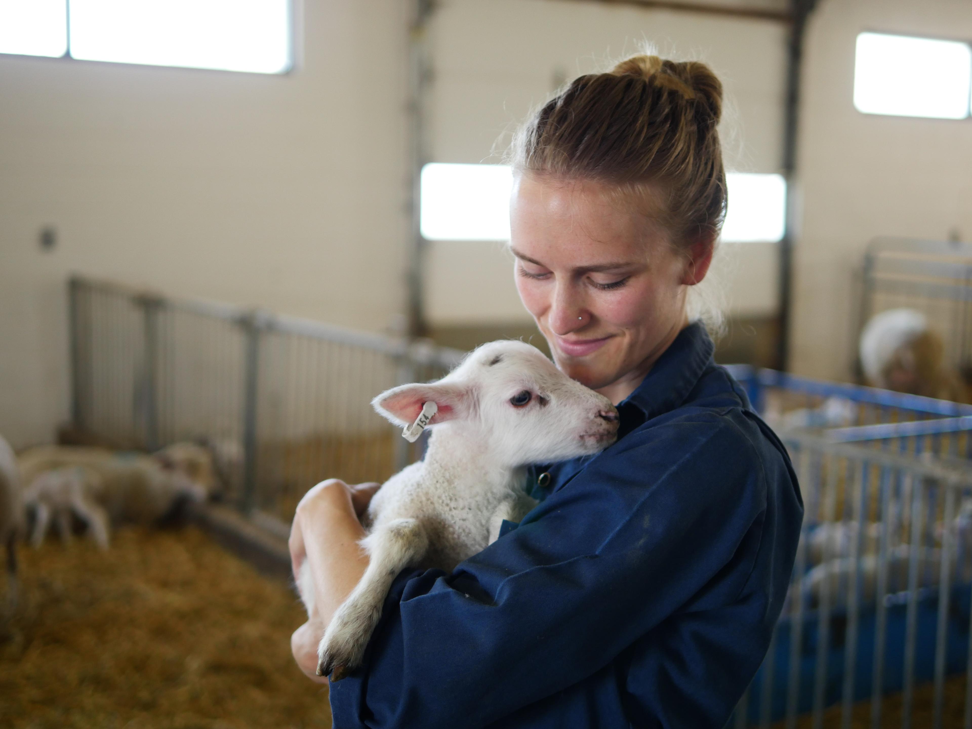A woman holding a lamb.