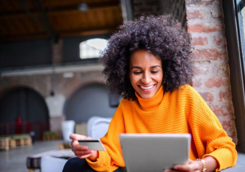 Woman looking at bank card and laptop