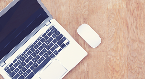 Laptop and mouse on wood background