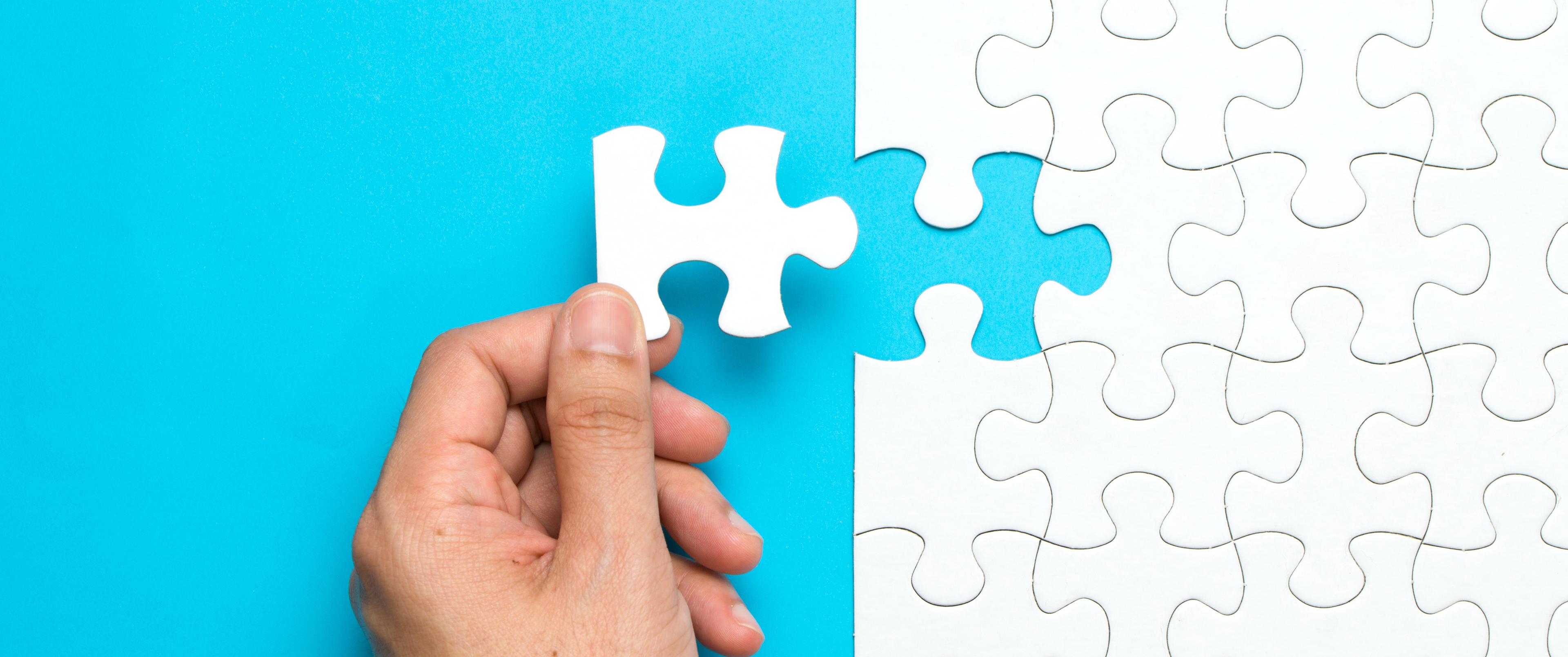 hand holding puzzle piece 