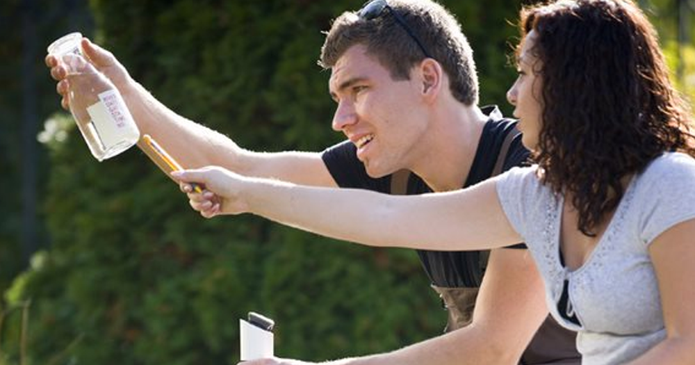 students inspecting a specimen from a pond
