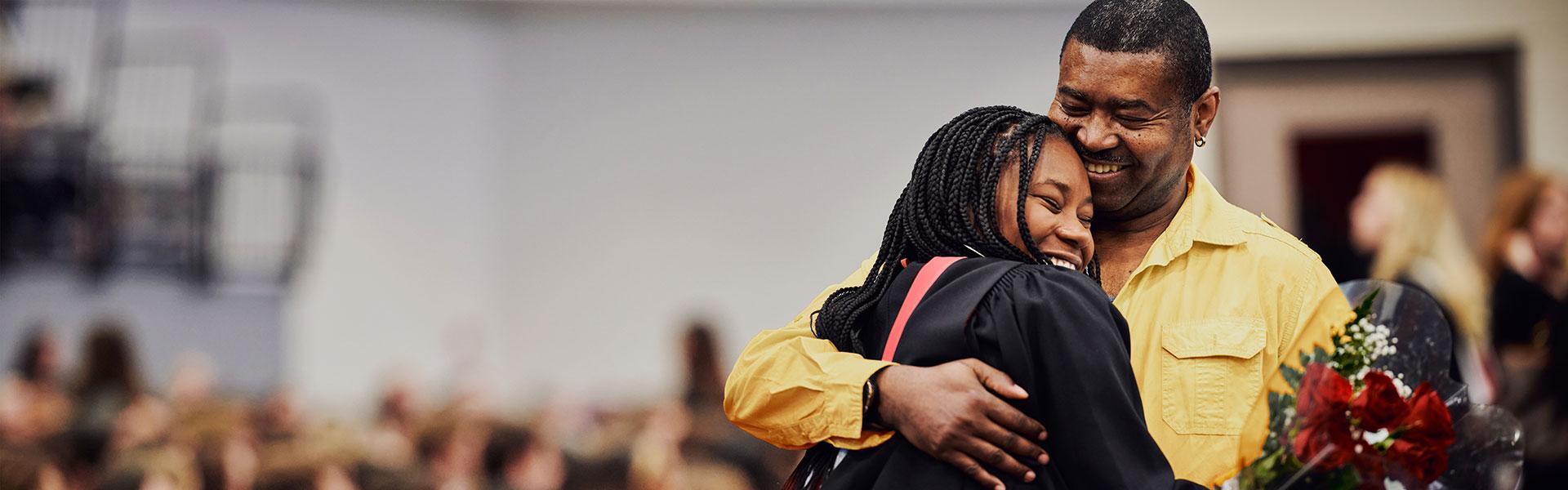 A University of Guelph student hugging her dad at her graduation ceremony