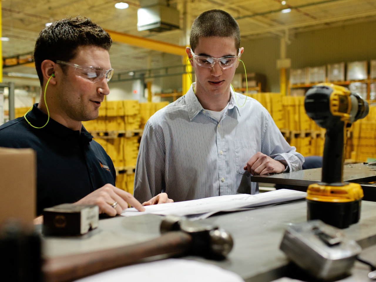 two engineers read paper in warehouse