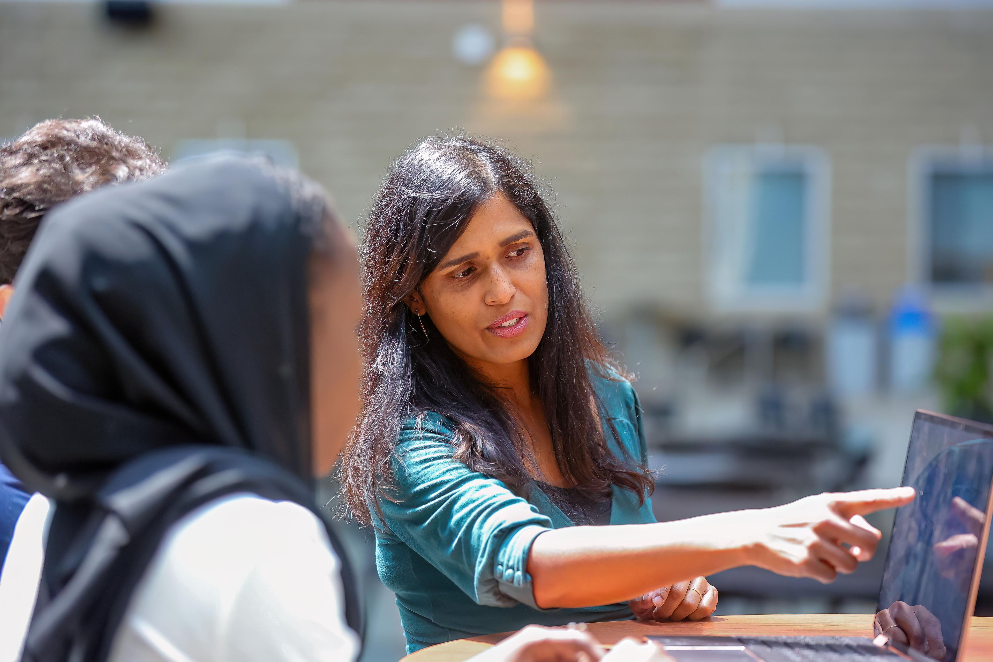 Professor with students and lap top