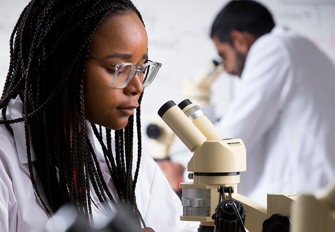 Woman looking through a microscope