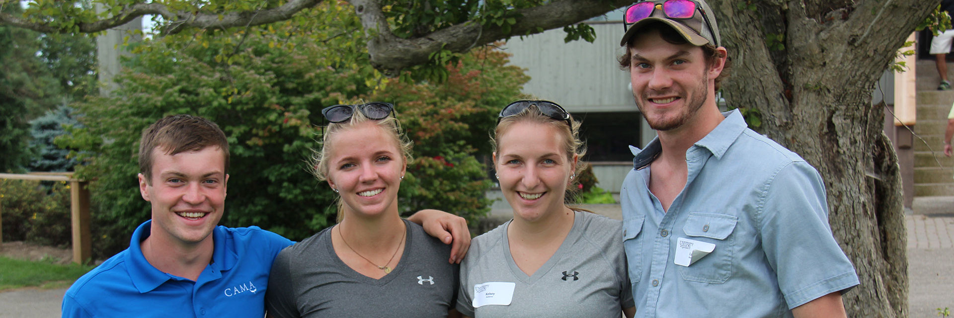 4 alumni of oac with arms around each other