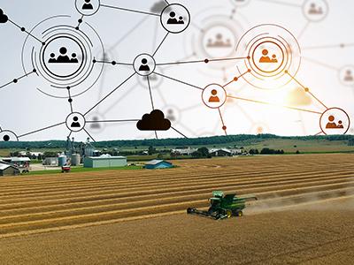 Aerial view of a wheat field being harvested with farm in the background and the sky replaced with icon graphics representing knowledge translation. 
