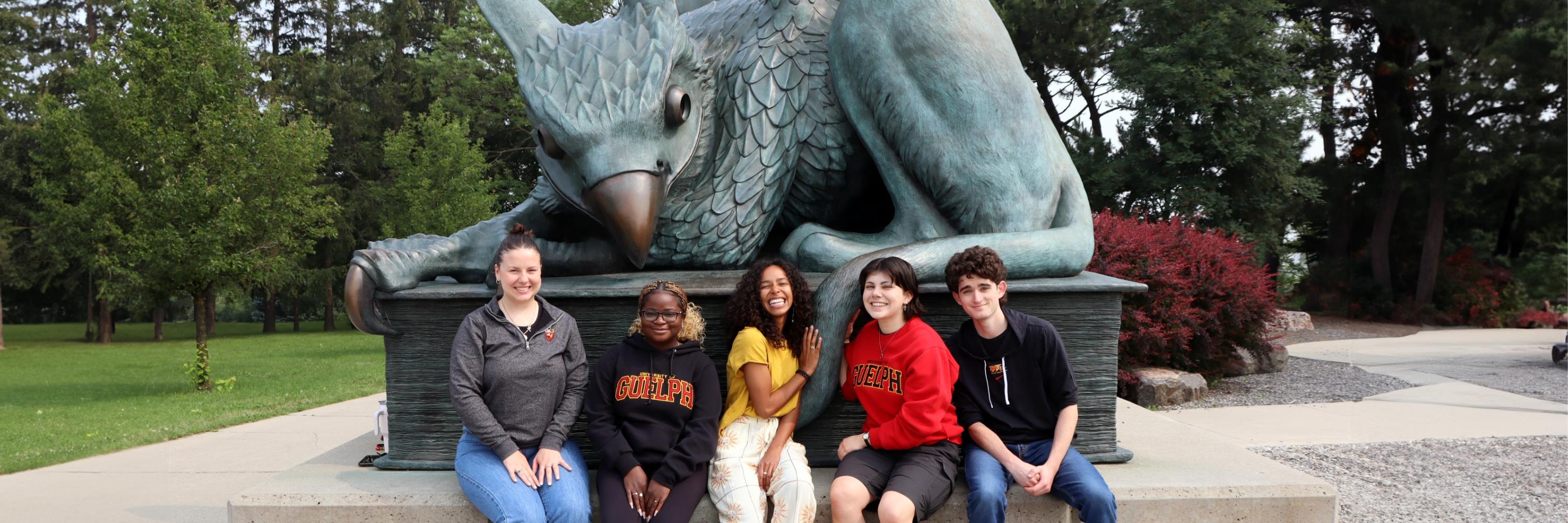 students with gryphon statue
