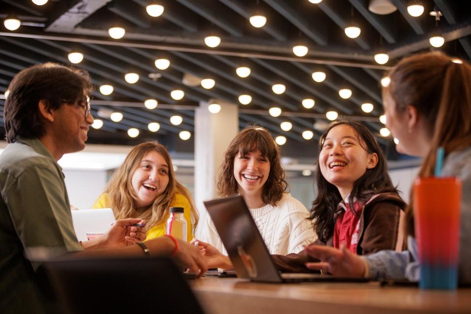 5 students chatting around a table