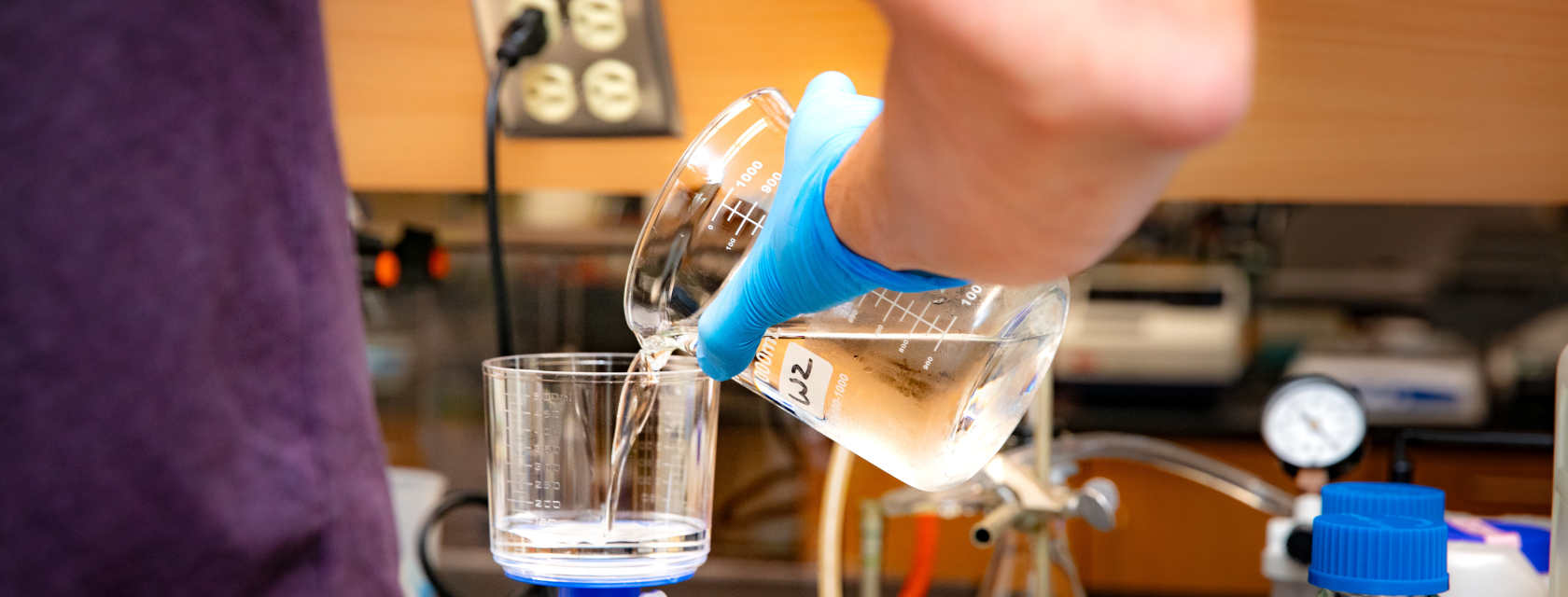 someone pours into a beaker