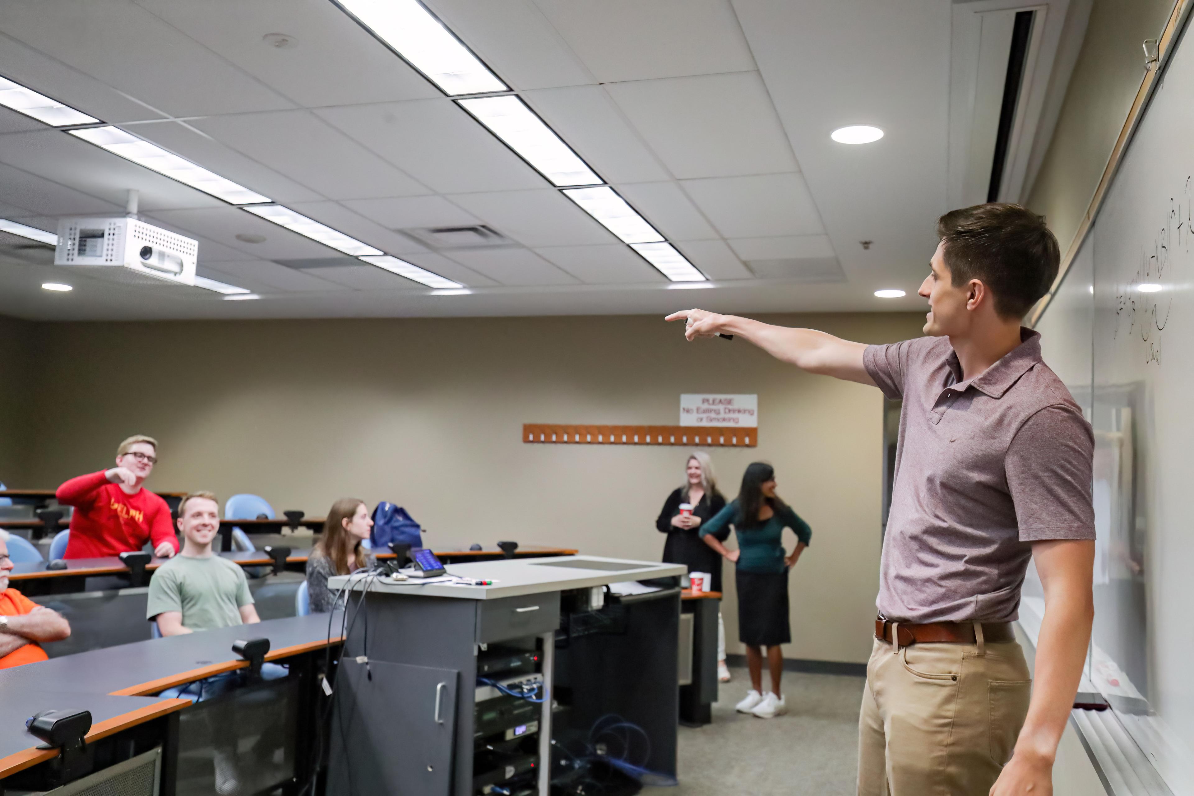 Professor pointing at students in lecture hall