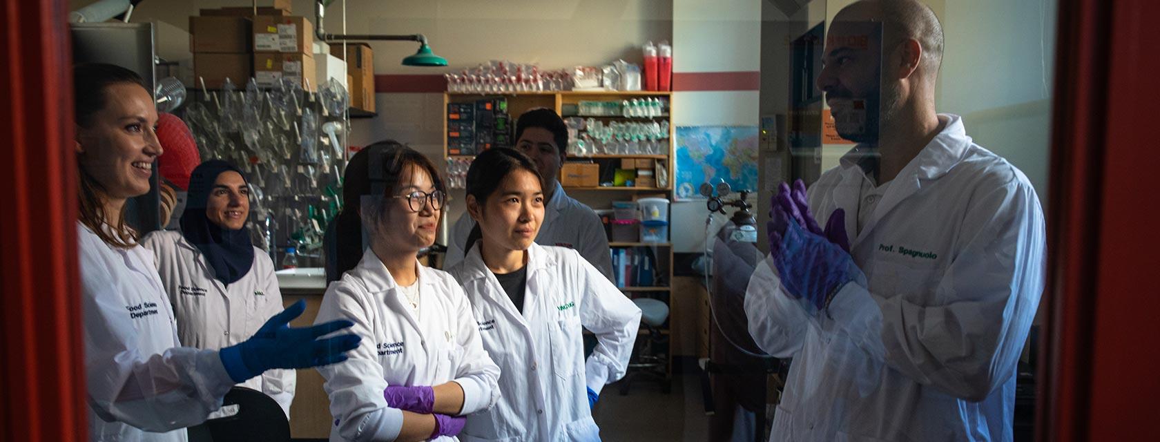 a team of scientists in a food inspection lab talking