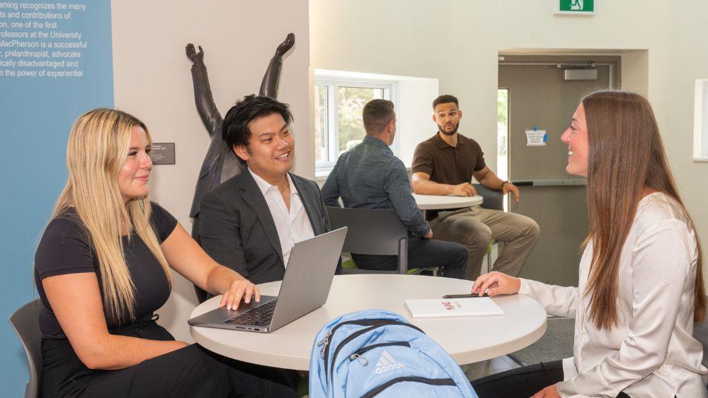 three people sitting at a table in McDonald Hall