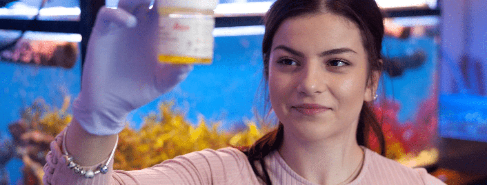 A student holding a container in a lab.