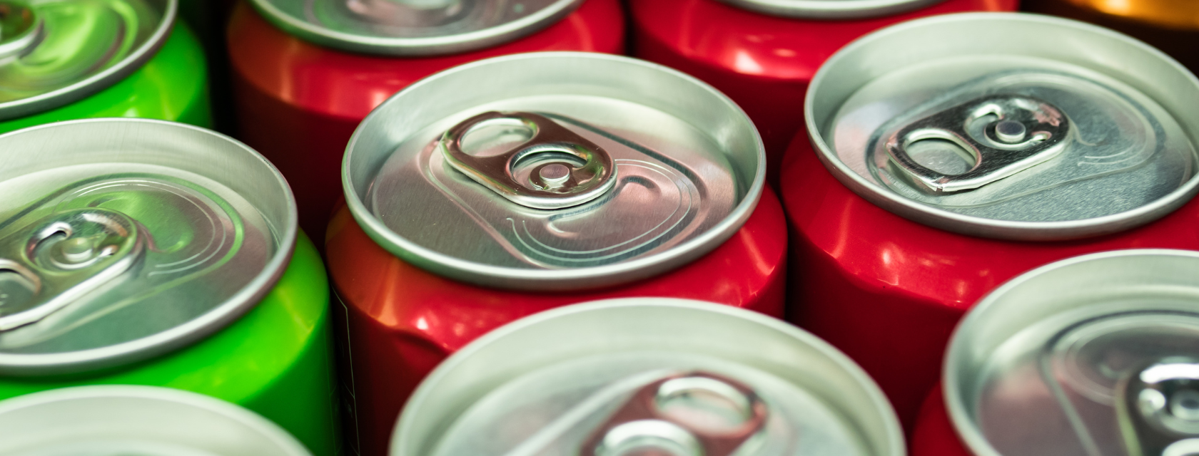A collection of soda cans stacked together.