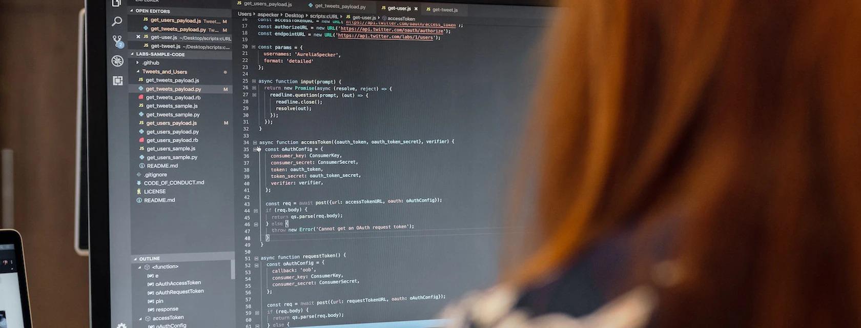 Student in front of a monitor displaying code on Visual Studio.