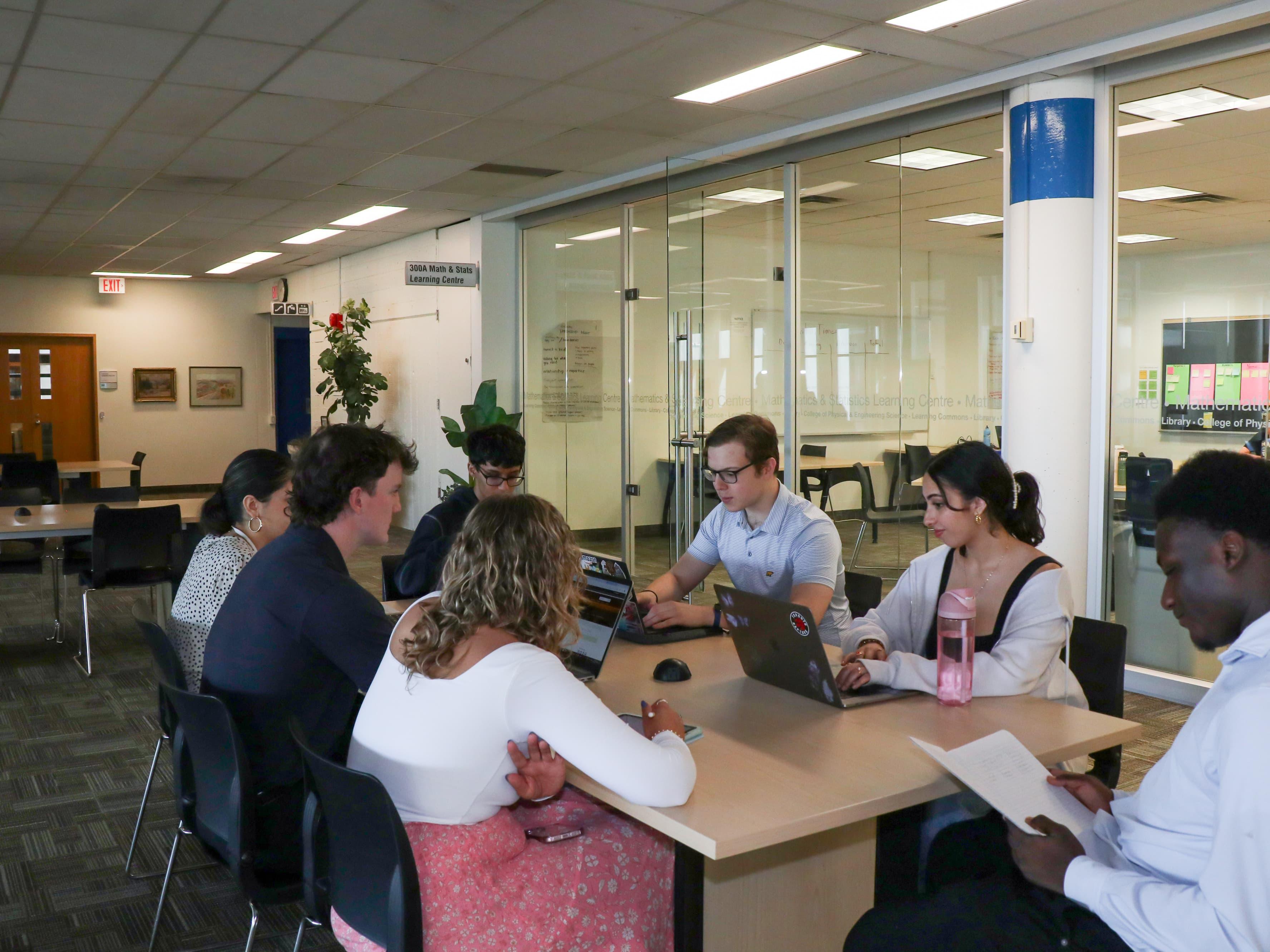 7 students studying around a table in the Math & Stats Learning Centre.