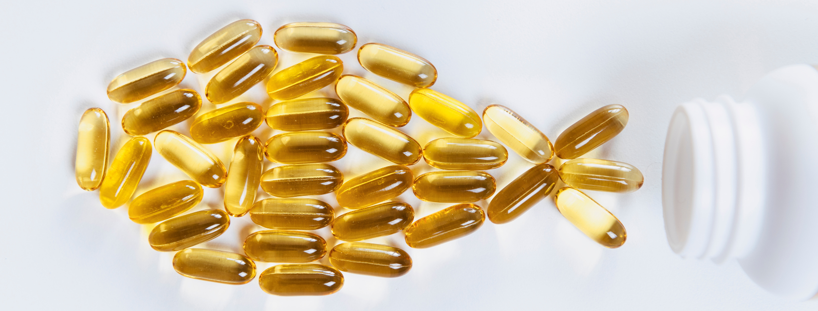 Fish oil capsules arranged on a white background, showcasing their translucent gel-like appearance and golden hue.