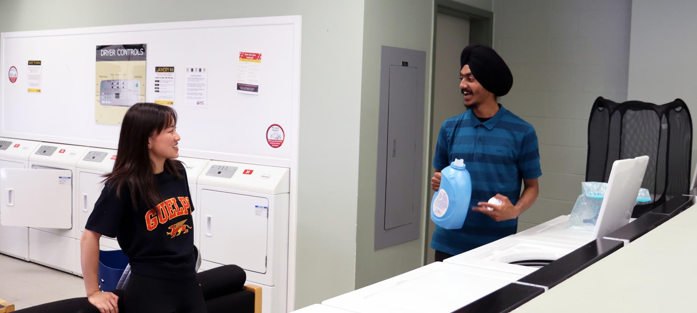 Two students doing laundry in East Residence