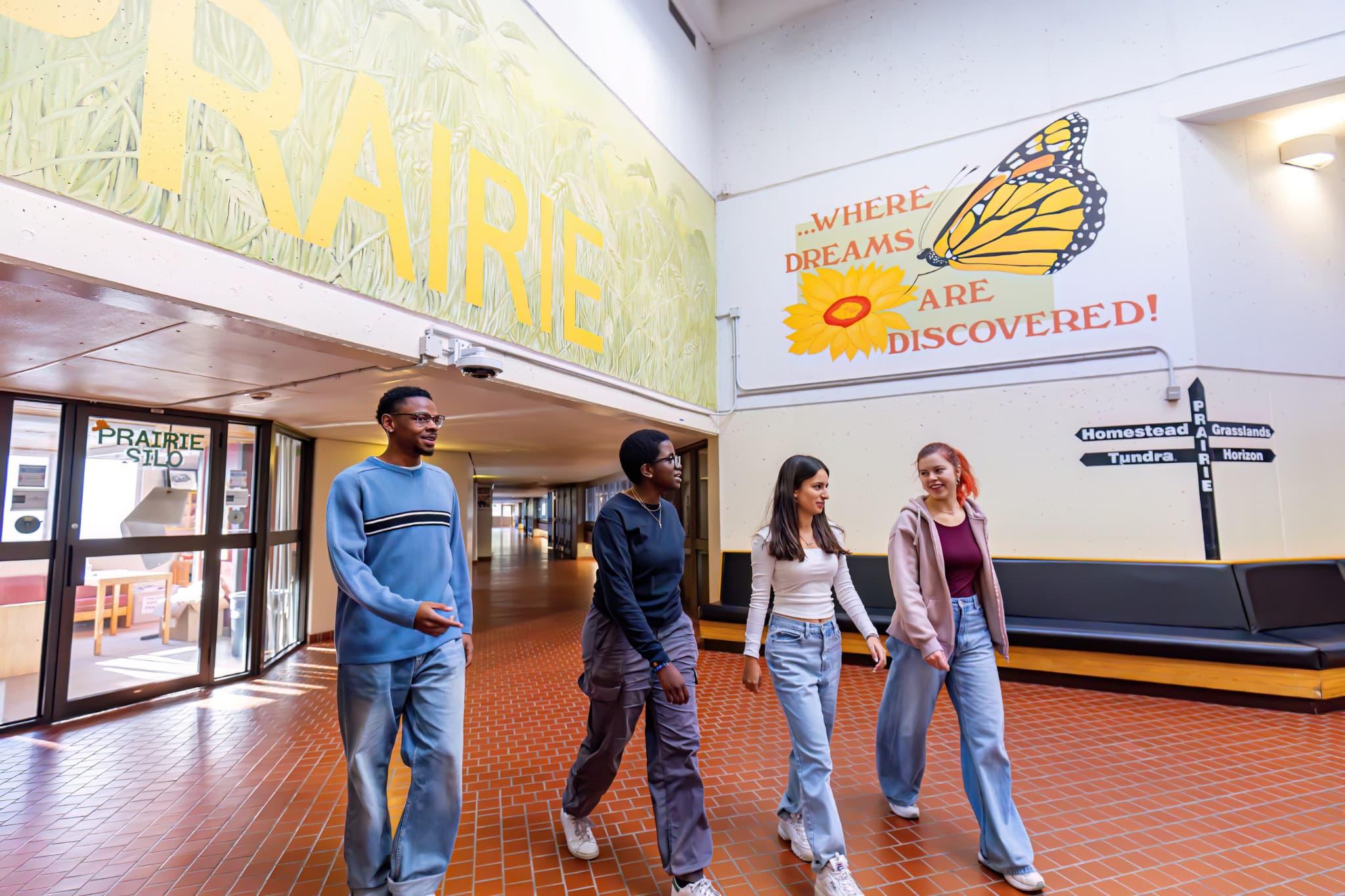 Four Students walking and talking in the Prairie hallway