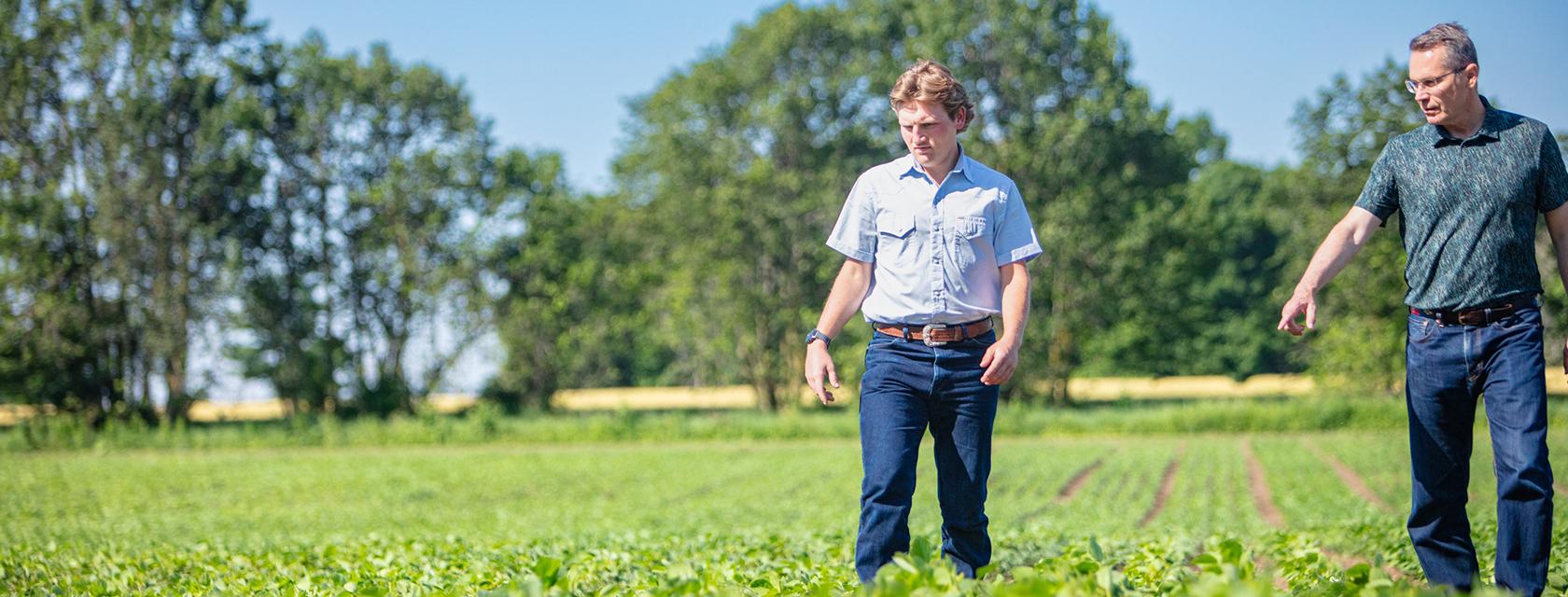 a student and faculty member walking in a field