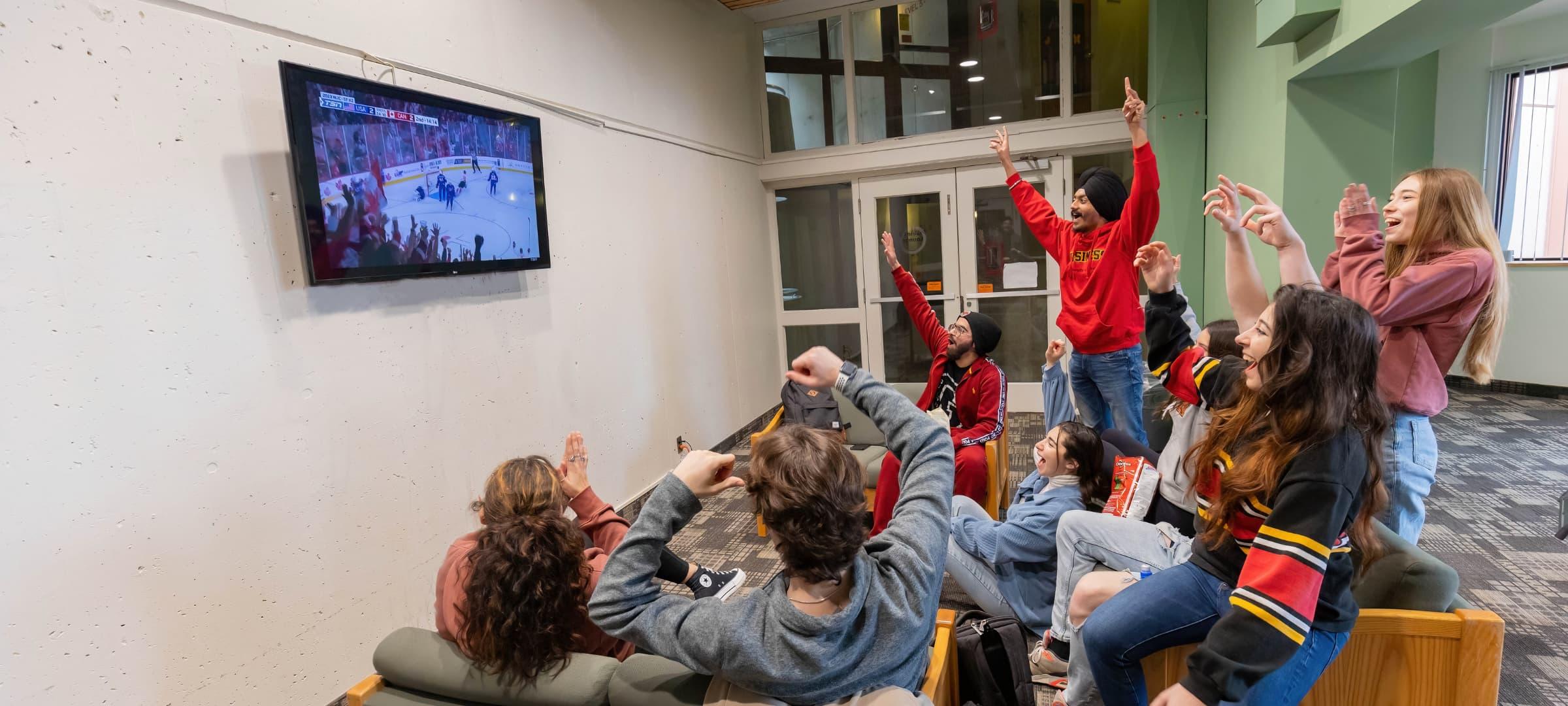 Students watching TV in the south residence lounge area