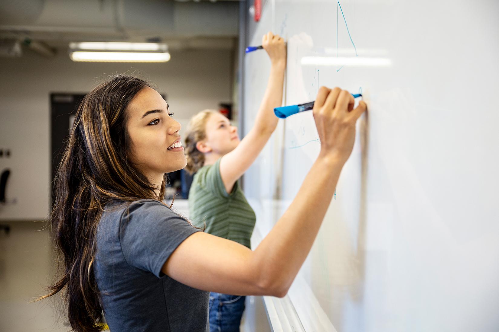 Female student using a whiteboard