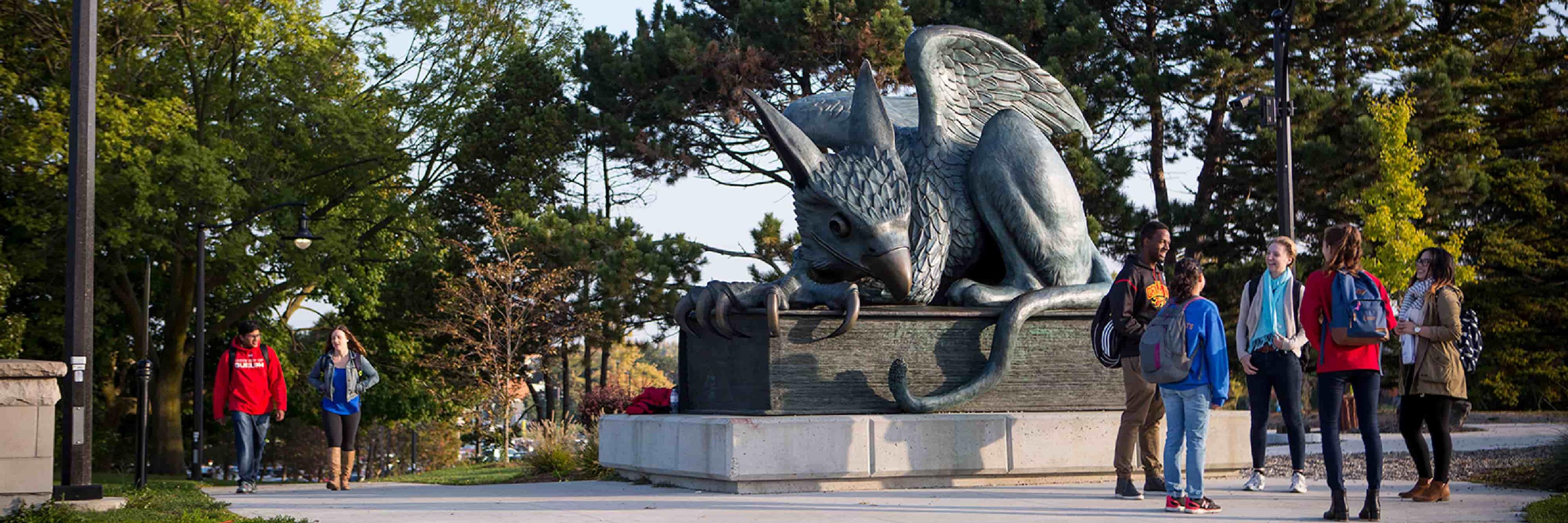 students in front of gryphon statue