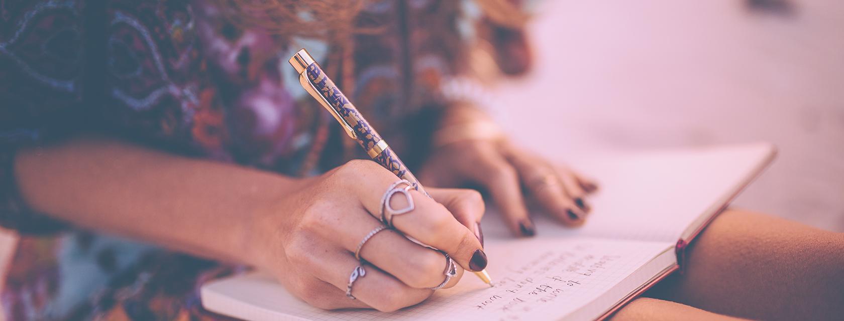 Closeup of a girl writing in a notepad.