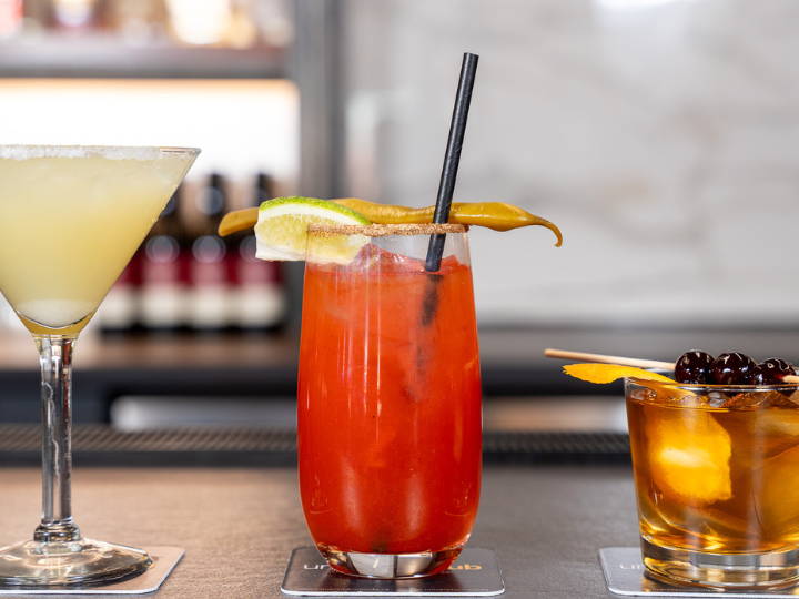 three drinks lined up on a bar top