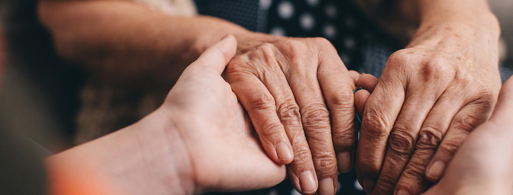 Closeup of clasping hands.