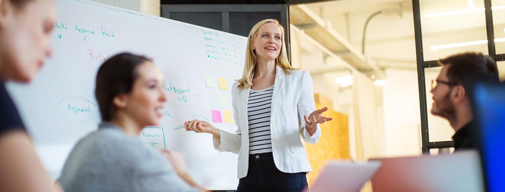 Young woman making a presentation to a small group of people.
