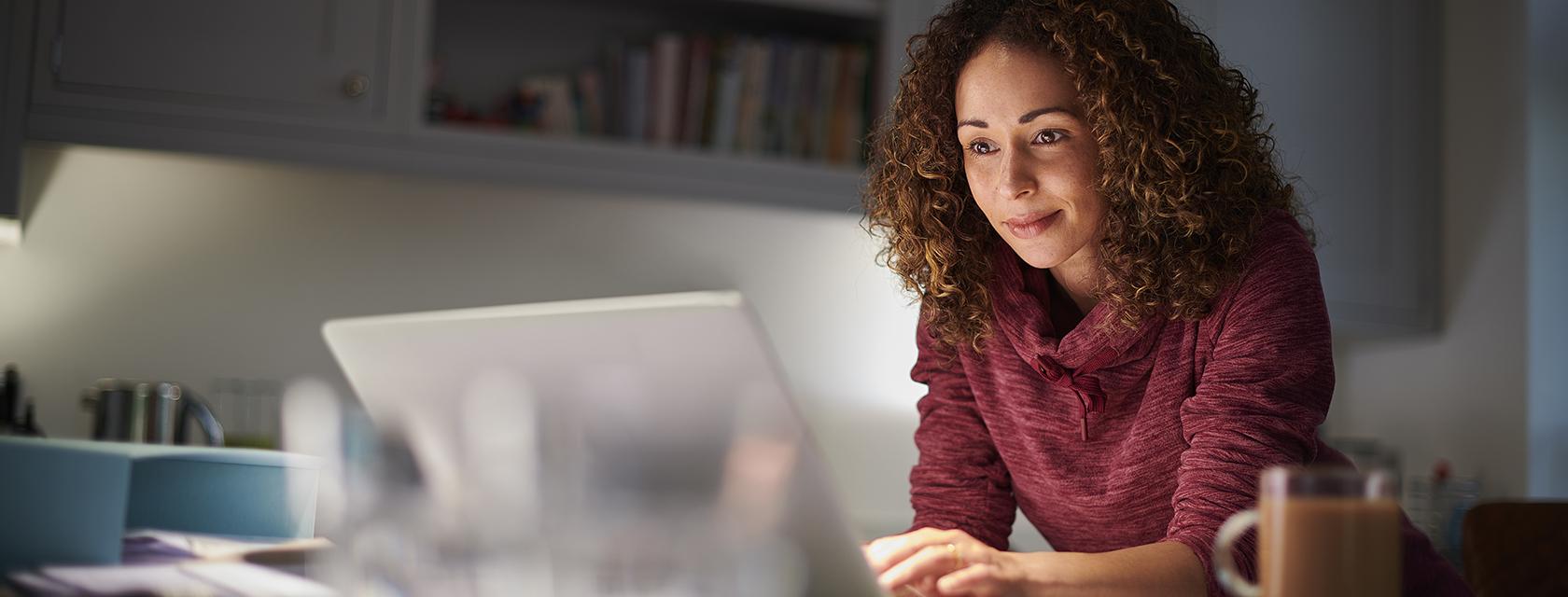 Smiling woman looking at a laptop.