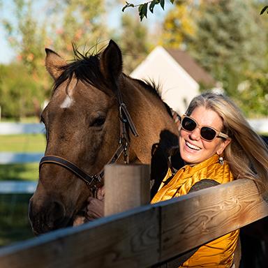 Smiling woman with her horse.