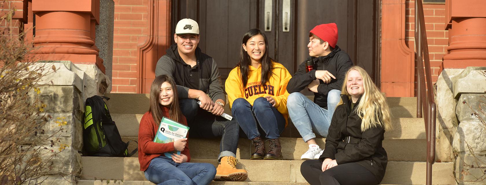 English Language Programs students sitting on steps on campus.