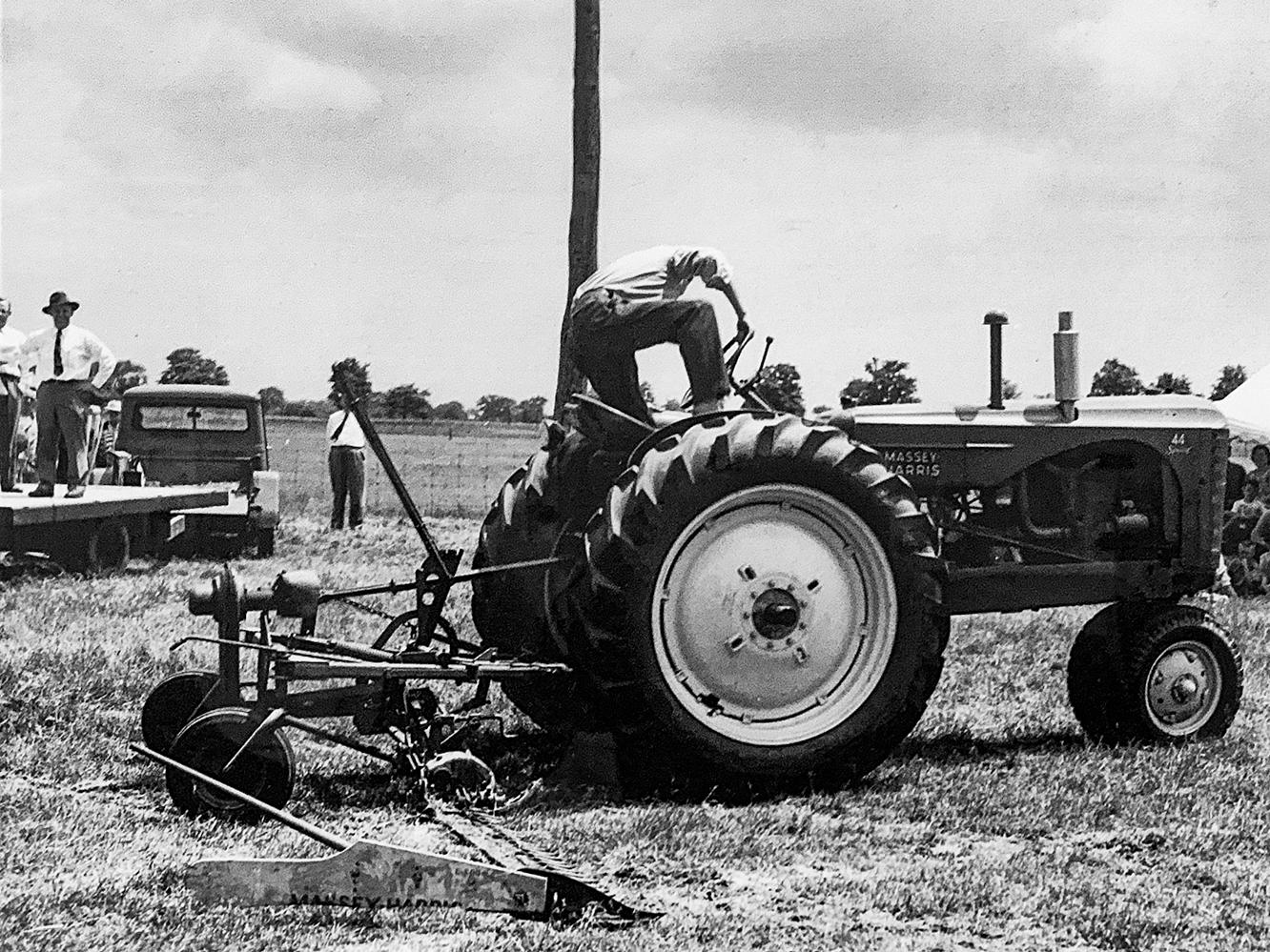 old black and white photo of a man working on a tractor