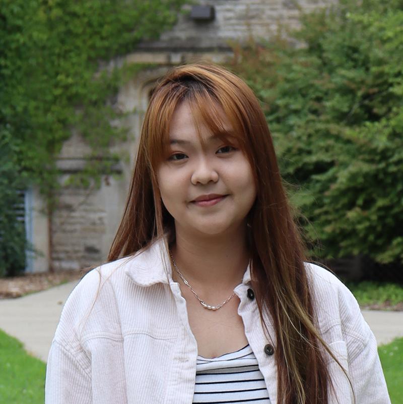 Young Asian woman standing in front of Johnston Hall.