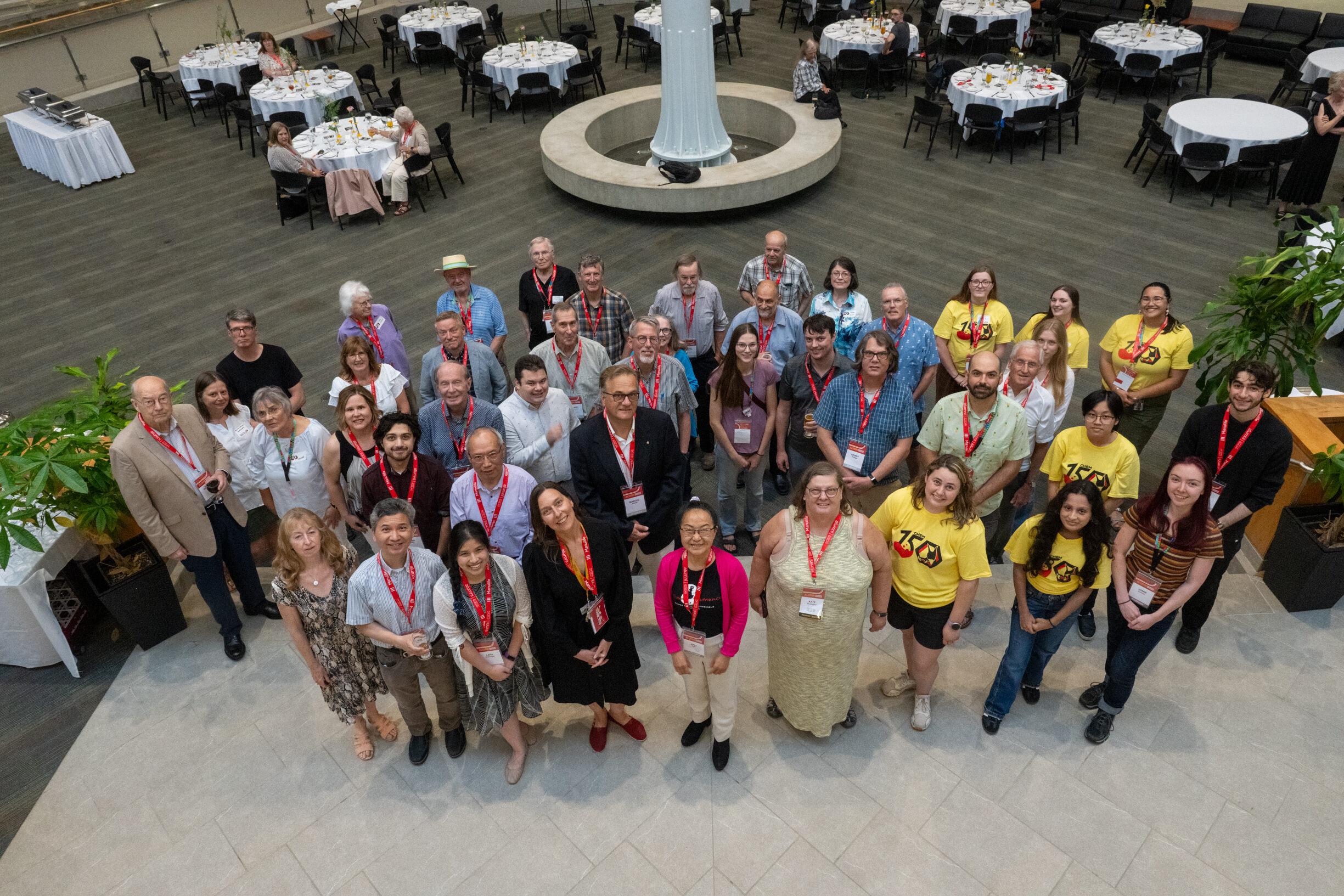 Arial view of a group of alumni standing together looking up.