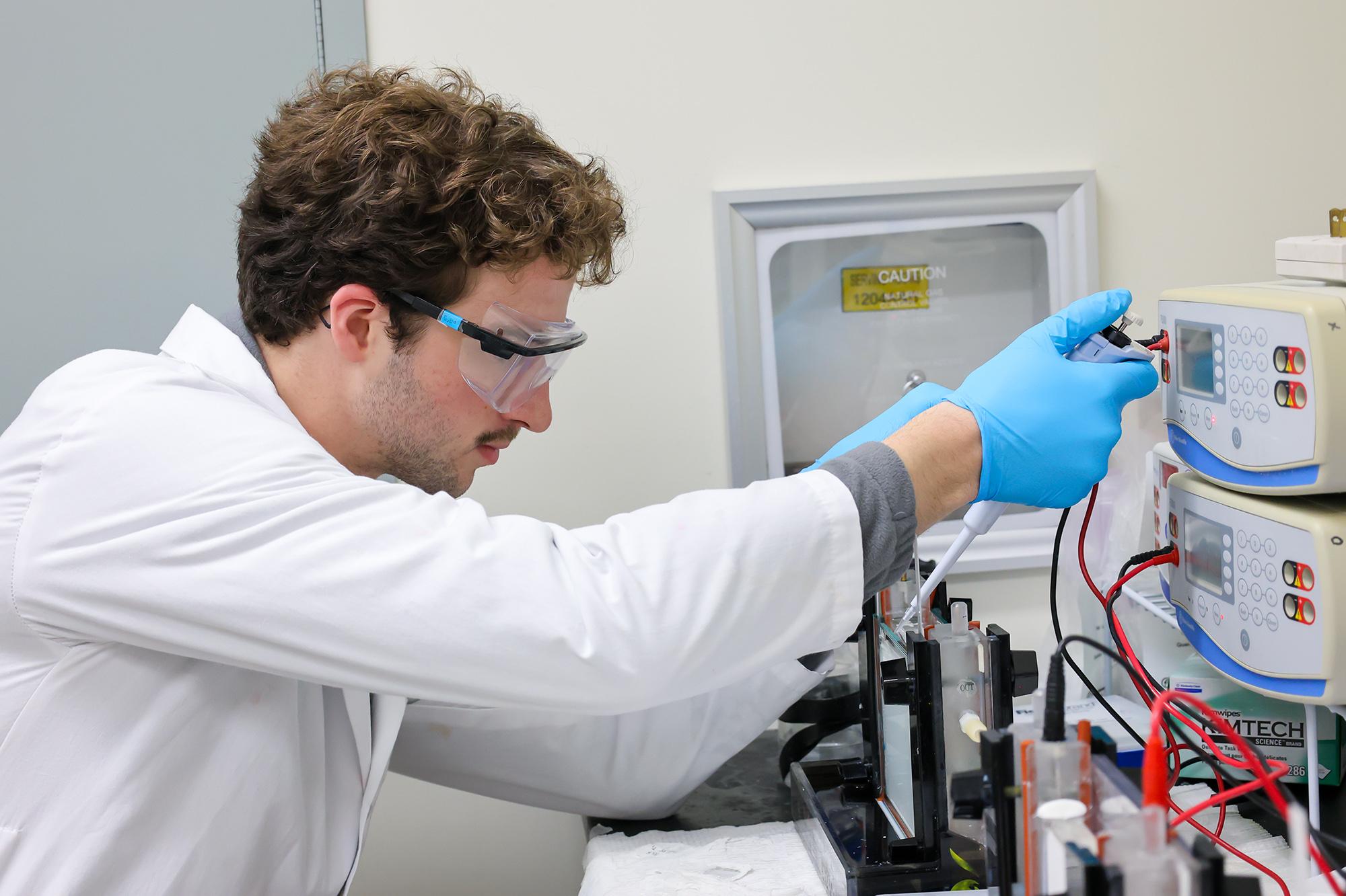 A student in a lab using a technical device. 