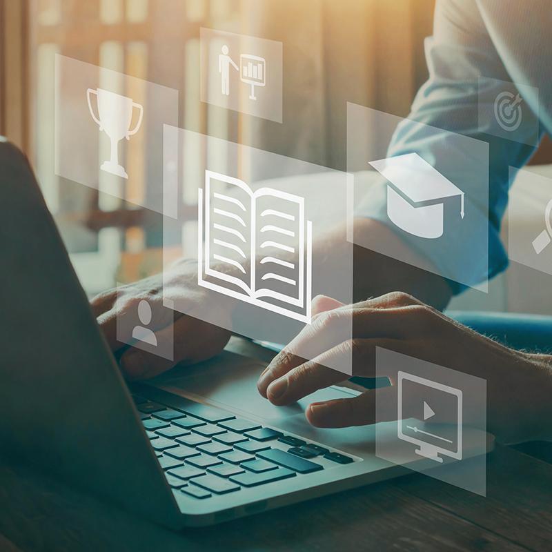 Layered image of hands on a laptop with faded icons.