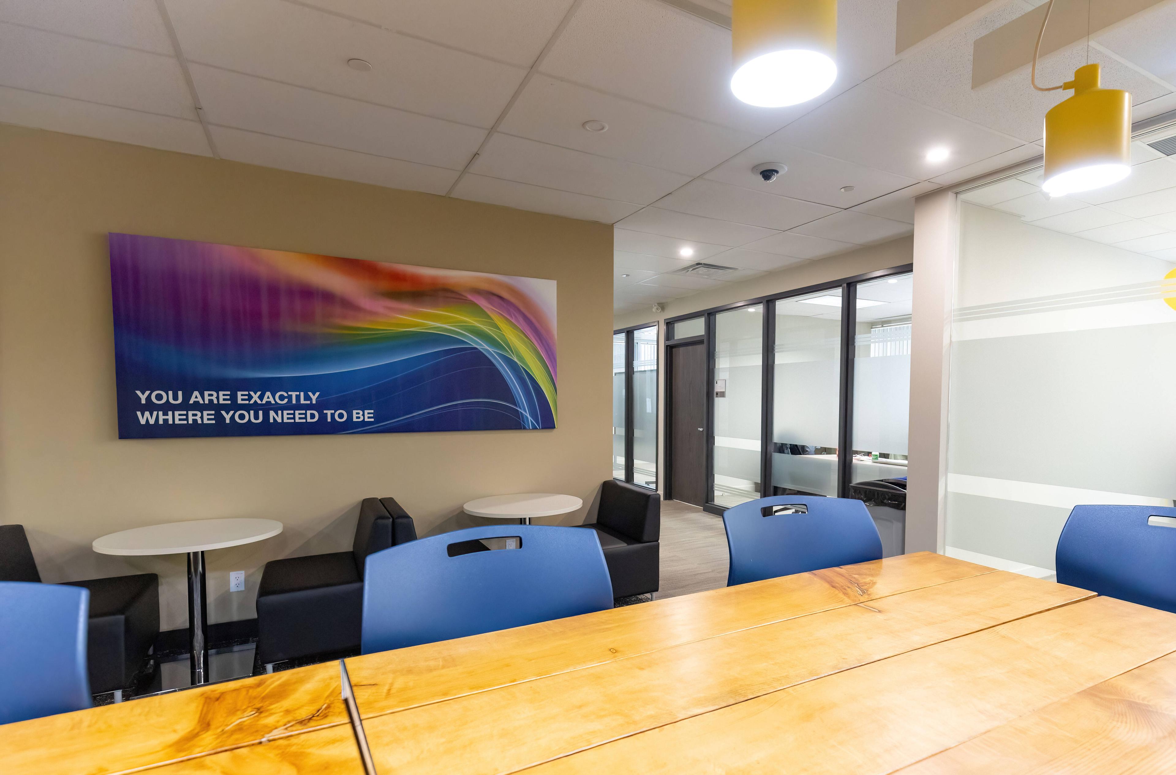 A table with chairs and a poster that reads "You are exactly where you need to be"