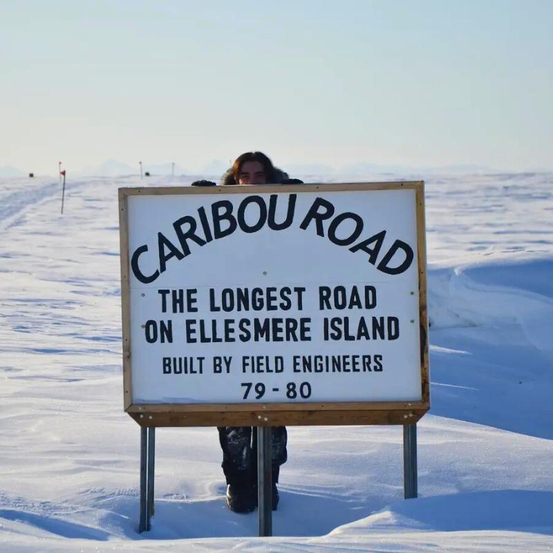 Student in front of Caribou Road sign