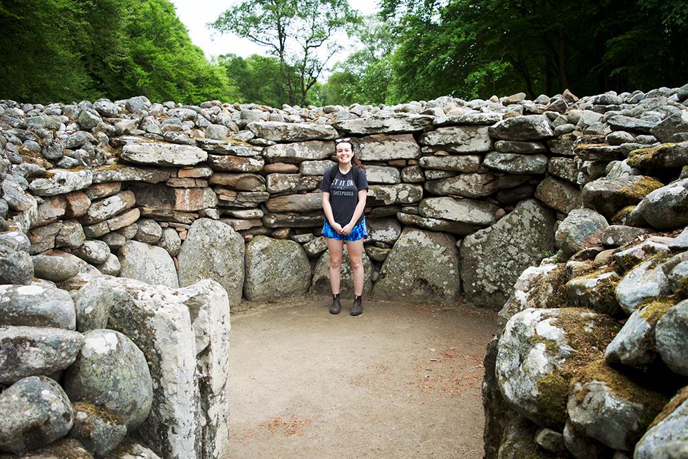 Woman standing inside an old stone house