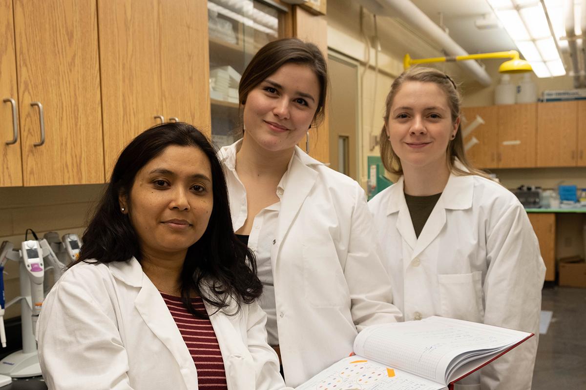 Three woman scientist in a lab smiling