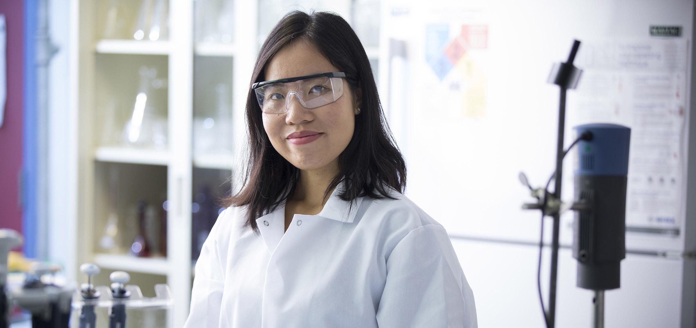 A person wearing a lab coat in a chemistry lab.