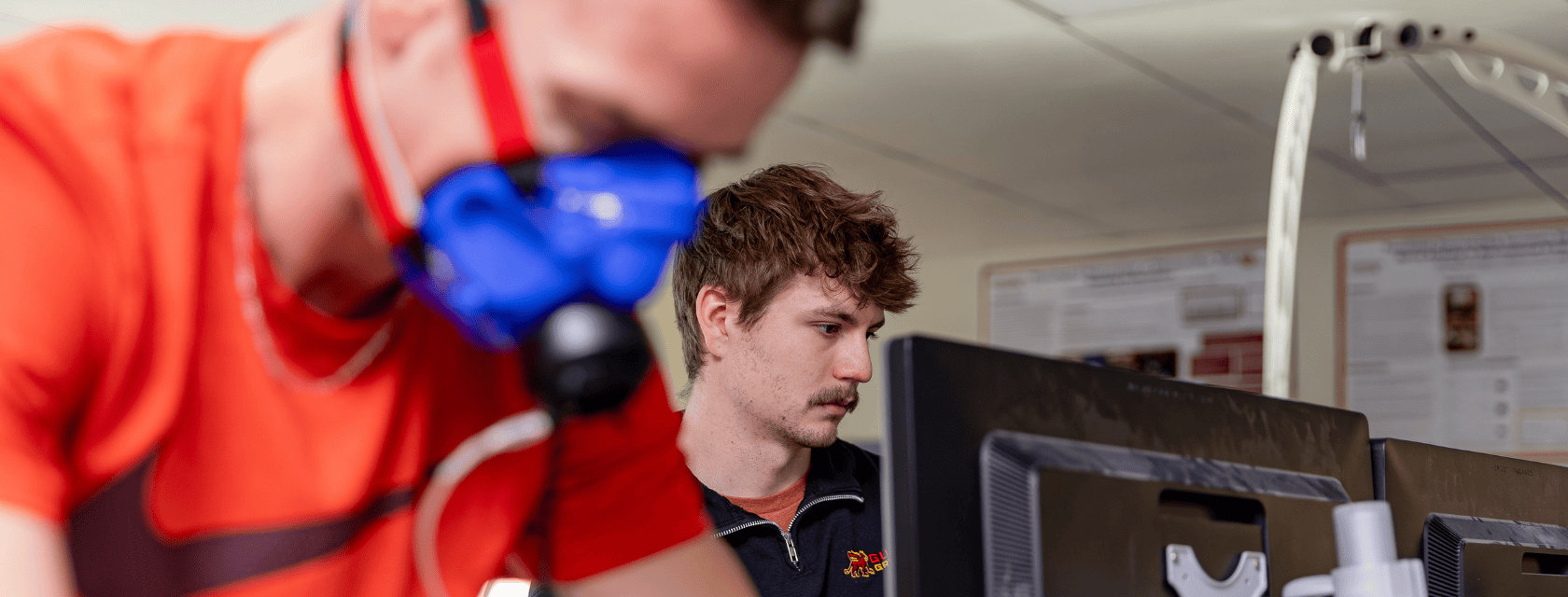 Student on an exercise bike while another looks at a monitor