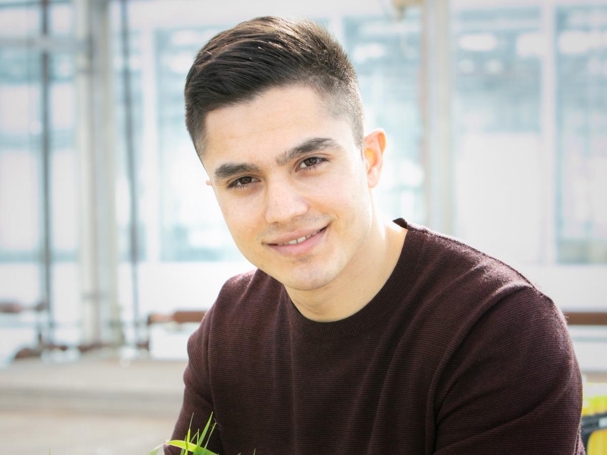 Profile photo of a smiling Jaber Husiny, shown from the shoulders up, in a greenhouse