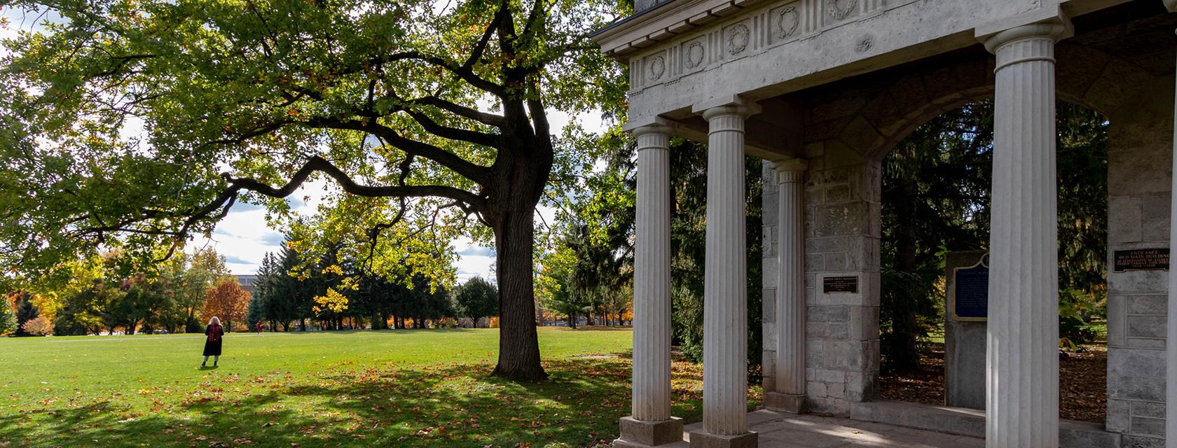 Solo graduate standing near the Portico on Johnston Green.