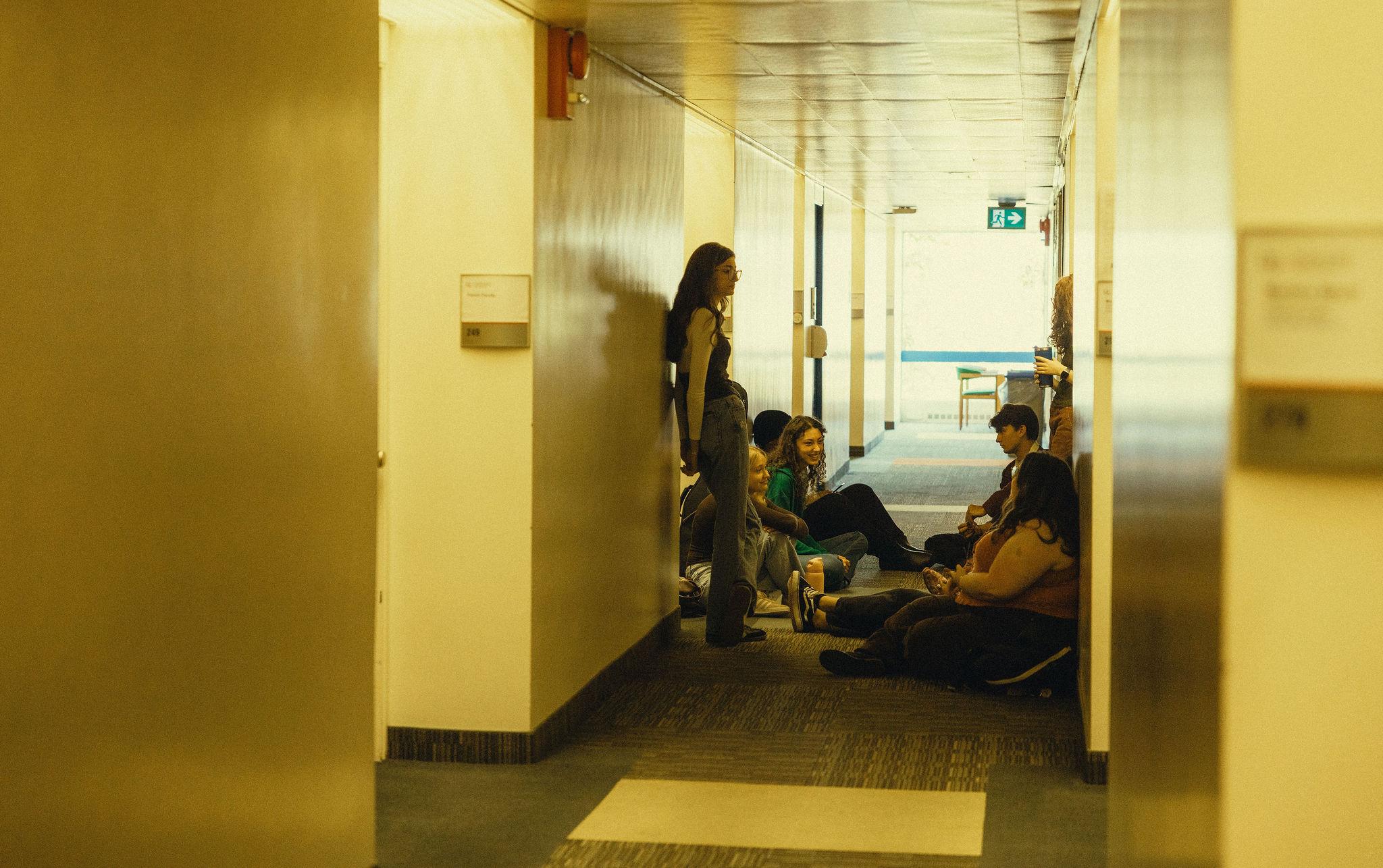 students sitting in hallway