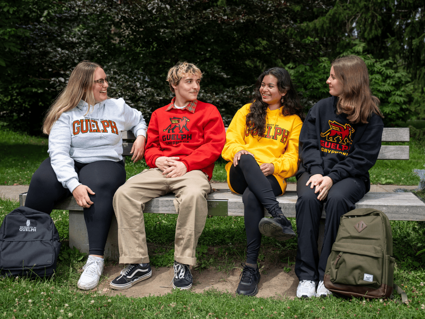 group of students sitting on a bench wearing u of g sweaters